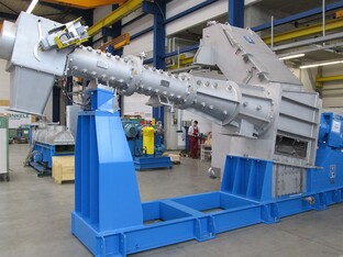 Ein Bauteil, welches zu einem Extruder gehört. Das Bauteil befindet sich in einer großen Halle zur Fertigstellung.