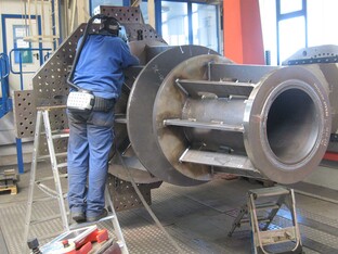 Industrielles Bauteil für den Royal Clock Tower mit vielen Komponenten. Eine Person, arbeitet an der Fertigstellung.