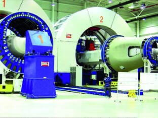 Großer industrieller Nietbalken in einer Fabrikhalle, zur Herstellung oder Bearbeitung von Flugzeug- oder Raumfahrtkomponenten.