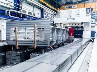 Eine große Zerspannungsmaschine in einer Fertigungshalle. Die Maschine bearbeitet Teile zur Fertigung.
