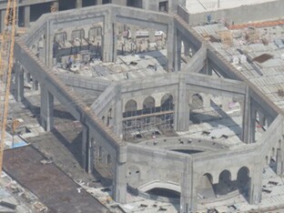 Sicht aus der Vogelperspektive auf ein großes, graues Gebäude, welches den Ceremonial Dome Mekka darstellt.